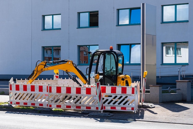 Gelber Bagger eingezäunt mit Verkehrssperren