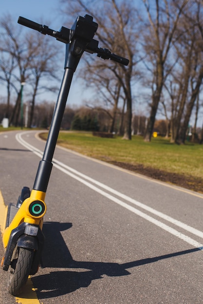 Gelber Elektroroller auf der Straße. Vermietung von Rollern