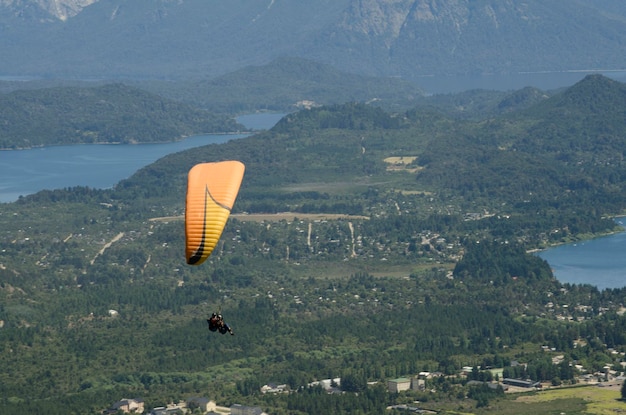 Gelber Gleitschirm über der Stadt Bariloche