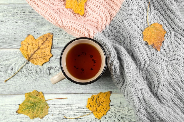 Gelber herbstlaub, eine tasse tee auf einem alten hölzernen hintergrund