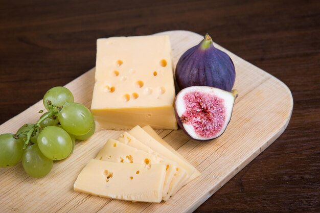 Gelber Käse und frische Feigen auf dem Holzschneidebrett