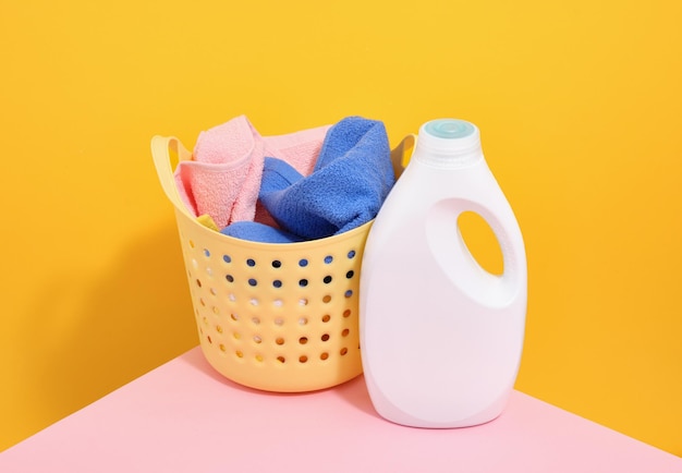Gelber Korb mit schmutziger Kleidung und Waschmittel Waschtag