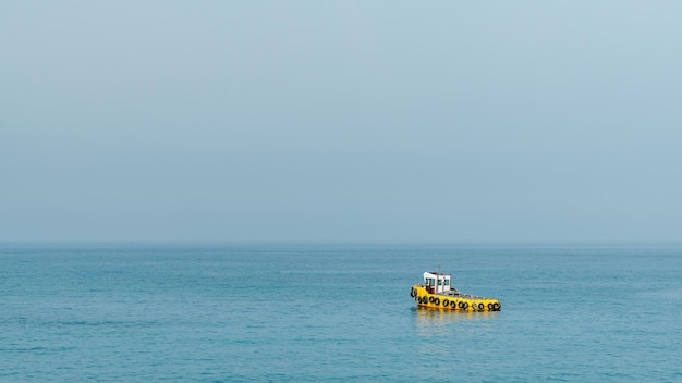 Gelber Schlepper im Mittelmeer Minimaler Hintergrund