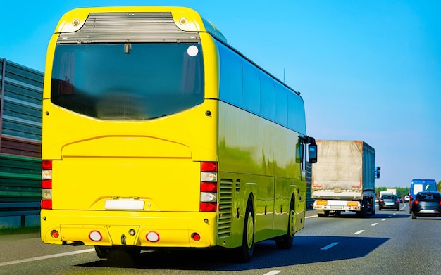 Gelber Shuttle-Bus zurück auf der Straße, Polen. Moderner ÖPNV-Verkehr und Sommerfahrt. Charterbusfahrzeug auf Urlaubsreise. Urlaubsreise zur Erholung. Bewegung und Stadtfahrt.