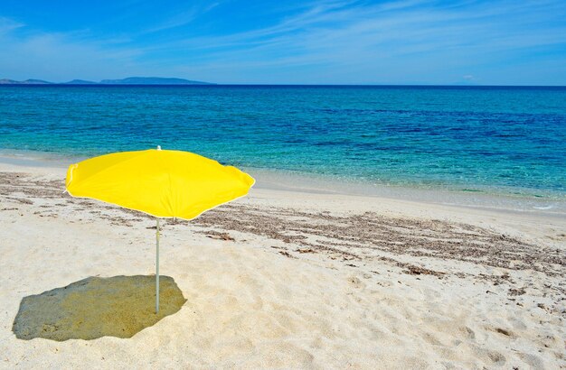 Gelber Sonnenschirm an einem einsamen Strand