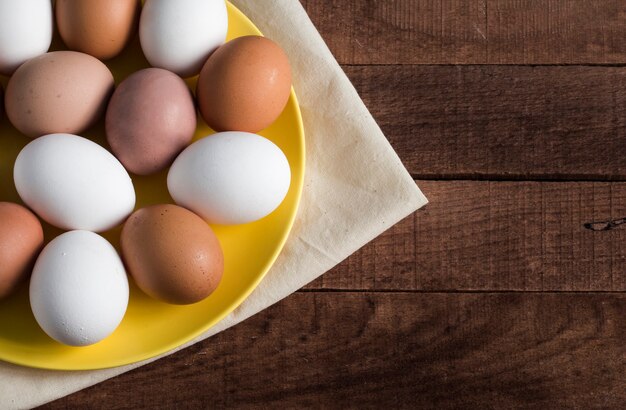 Gelber Teller mit ganzen Eiern auf einer Serviette, Draufsicht mit einer Kopie des Raumes.