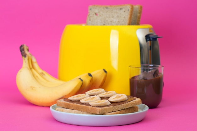 Gelber Toaster auf einem rosa Hintergrund