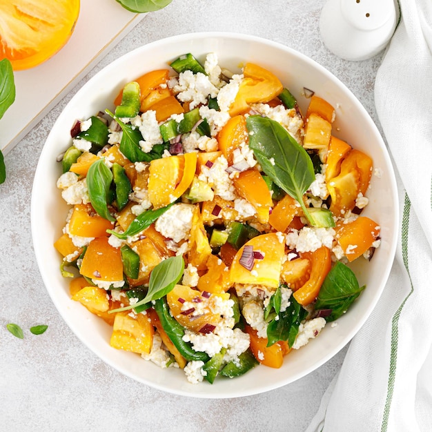 Gelber Tomatensalat mit grünem Paprika Hüttenkäse und Basilikum Gesunde Ernährung Draufsicht