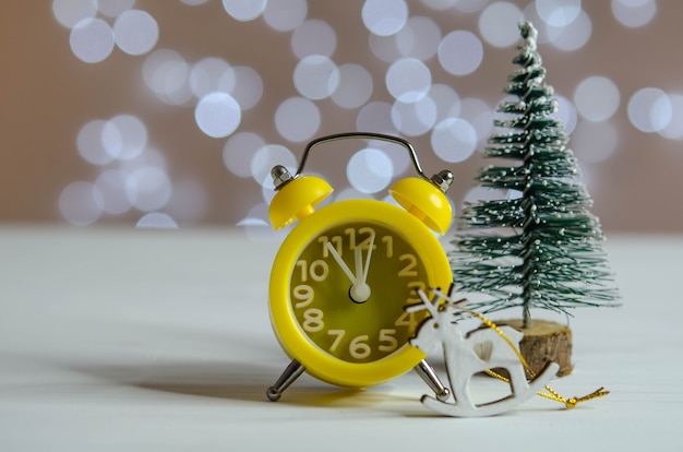 Gelber Wecker und ein Weihnachtsbaum auf dem Tisch