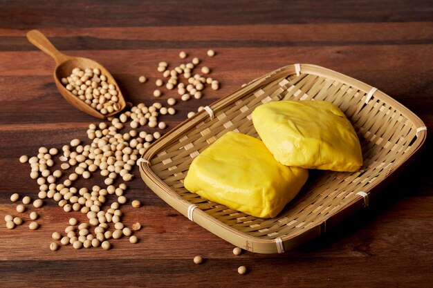 gelber weicher tofu und sojabohnen auf holzhintergrund