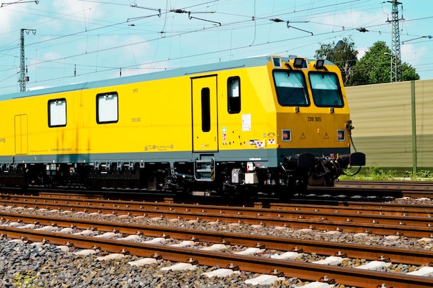 Gelber Zug auf Eisenbahnschienen gegen den Himmel