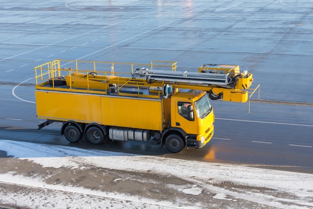 Gelbes Auto auf dem Flugplatz am Flughafen enteisen