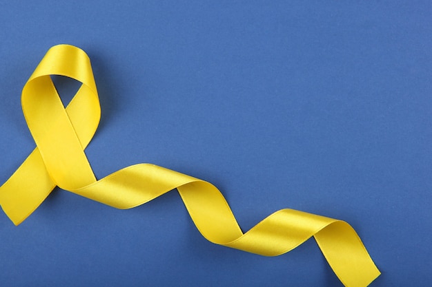 Gelbes Band als Symbol für Krebs in der Draufsicht der Kinder