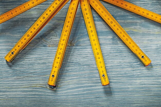 Gelbes Holzmeter auf Vintage-Holz-Hintergrund-Baukonzept.