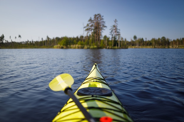 Gelbes Kajak mit einem Paddel auf dem See