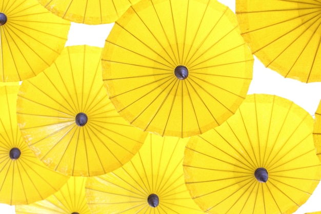 Gelbes Regenschirmmuster auf weißem Hintergrund