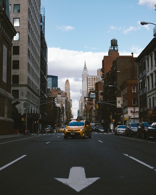 Foto gelbes taxi auf einer stadtstraße mit chrysler-gebäude im hintergrund