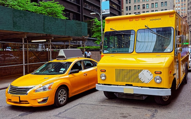 Gelbes Taxi und Schulbus unterwegs. Blick auf die Straße im Financial District von Lower Manhattan, New York, USA. Stadtbild mit Wolkenkratzern in den Vereinigten Staaten von Amerika, NYC, US. Amerikanische Architektur.