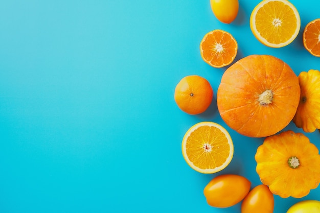 Gelbes und orangefarbenes Obst und Gemüse auf blauem Hintergrund Herbstkonzept Kopienraum