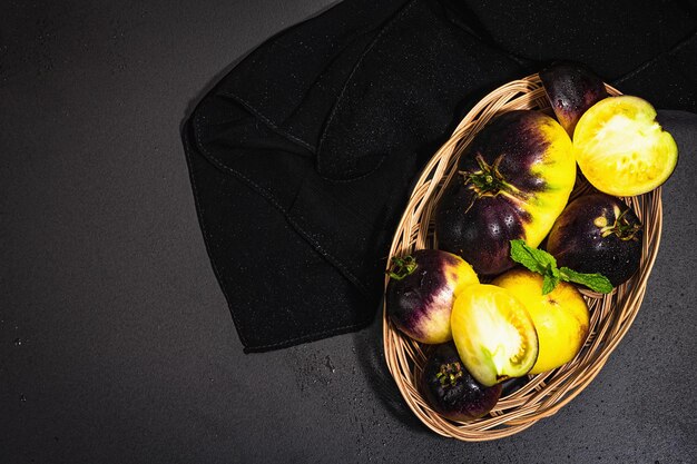 Gelbviolette Tomatensorte Primärfarben in einem Weidenkorb Ernte von reifem Gemüse