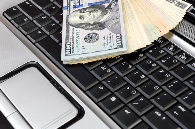 Geld auf der Laptoptastatur Schließen Sie herauf Geschäftskonzept