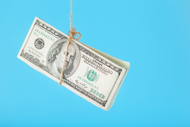 Geld gebunden Dollar an einem Seil, auf einem blauen Hintergrund