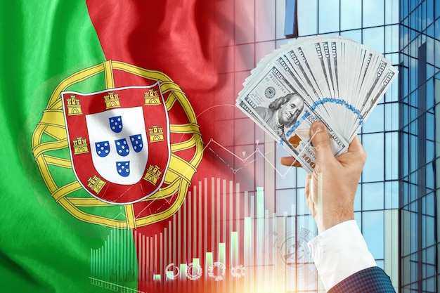Geld in der Hand eines Mannes vor dem Hintergrund der Flagge Portugals