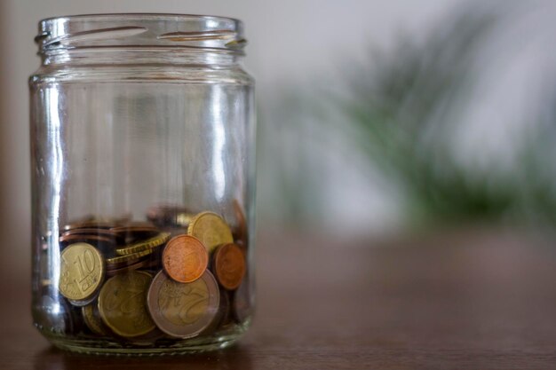 Geld in einem Glaskrug auf einem Holztisch