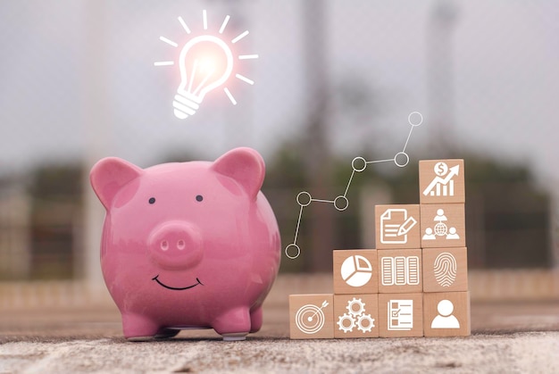 Foto geld sparen schwein sparschüssel mit graph-geschäft das icon finanzen auf holzblock geld sparen investme