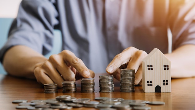 Geld sparen und Investition Wachstum Konzept Geschäftsmann Hand halten Münze auf Stapel Münzen mit weißen Pfeilen aufsteigend Finanz- und Geschäftsmanagement Geld für den Ruhestand Steuer Bankdepositen Buchhaltung