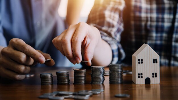 Geld sparen und Investition Wachstum Konzept Geschäftsmann Hand halten Münze auf Stapel Münzen mit weißen Pfeilen aufsteigend Finanz- und Geschäftsmanagement Geld für den Ruhestand Steuer Bankdepositen Buchhaltung