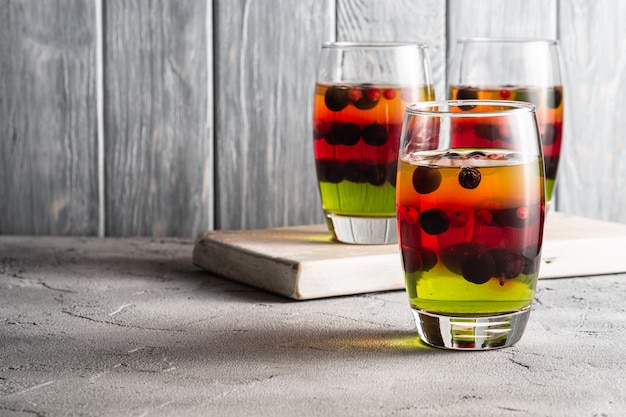 Gelee-Dessert mit Beeren in Gläsern auf altem Holzschneidebrett