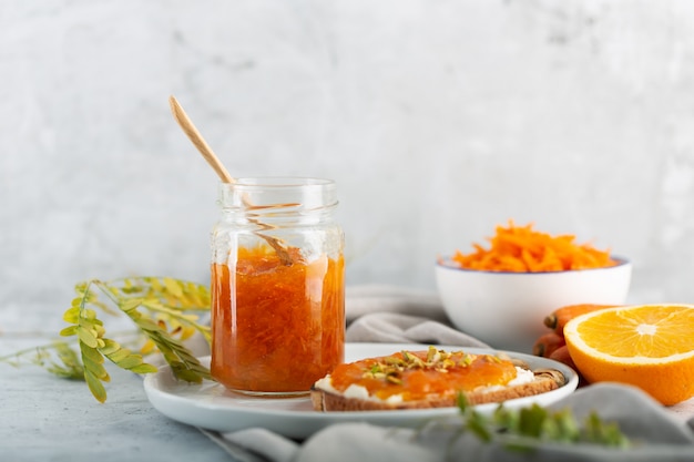 Geléia de cenoura com suco de laranja em fundo cinza