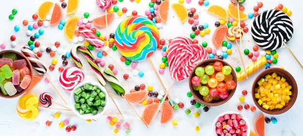 Geleia de doces coloridos e marmelada em um fundo branco de madeira Doces vista superior com espaço livre para cópia