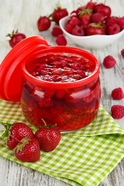 Geléia de frutas vermelhas caseiras na mesa de madeira