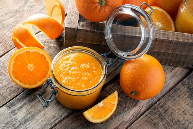 Geléia de laranja em uma jarra na parede de madeira.