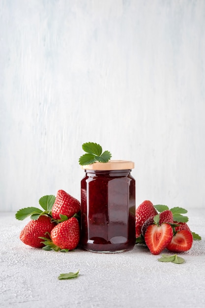 Geléia de morango em frasco de vidro e pedaços de morango. Preservando. Conservação da casa, preparação de alimentos.