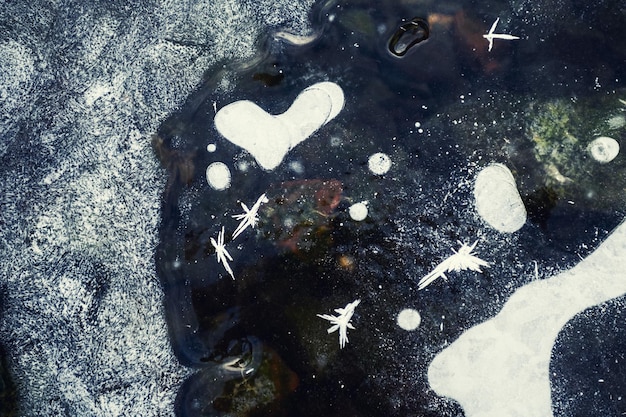Gelo bonito com bolhas de ar e gelo no lago congelado. Imagem macro. Bolhas de ar em forma de coração na superfície do gelo. Fundo de natureza de inverno
