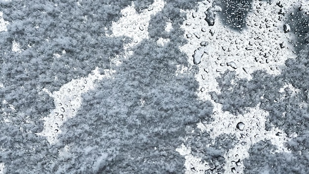 Gelo de neve e gotas de chuva em uma superfície de metal cinza Fundo com gotas de chuva