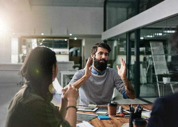 Gemeinsam die besten kreativen Ideen entwickeln Aufnahme einer Gruppe von Designern bei einer Diskussion in einem Büro