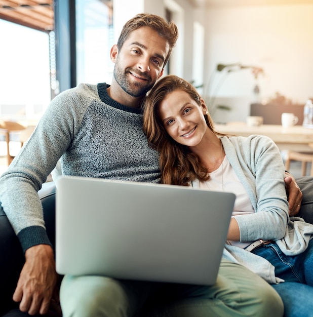 Gemeinsame Wochenenden drinnen sind immer die besten Porträt eines liebevollen jungen Paares, das einen Laptop benutzt, während es sich zu Hause auf dem Sofa entspannt