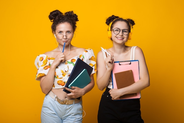 Gemelos de pelo rizado sonriendo a la cámara a través de gafas con auriculares