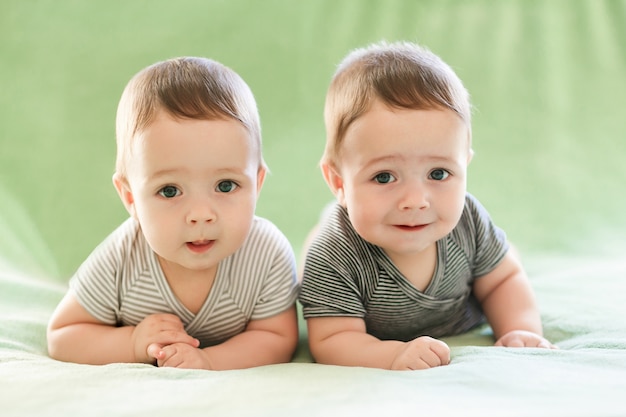 Gemelos recién nacidos, los niños están acostados en la cama.