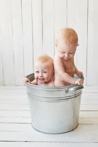 gemelos tomando un baño en un balde