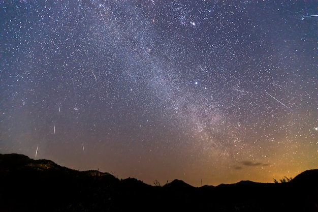 Geminid Meteorschauer und die Milchstraße über einen Berg. Geminid Meteor am Nachthimmel