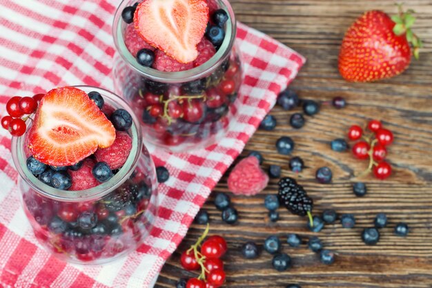 Gemischte beeren in einem glas auf braunem holztisch