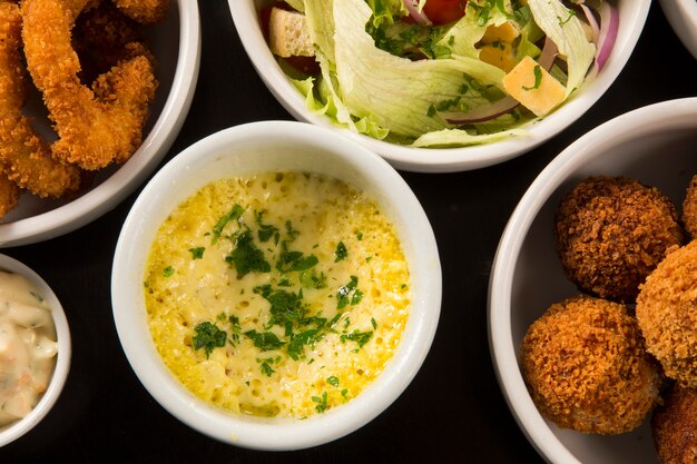 Gemischte brasilianische Snacks, darunter Gebäck, Brathähnchen, Salate, Suppen, Pommes und Kibe