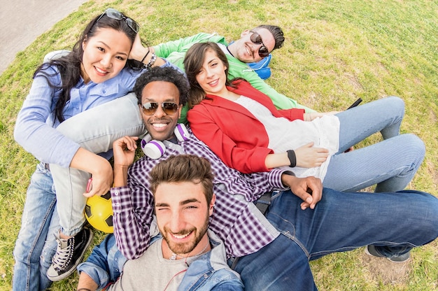 Gemischtrassige beste Freunde, die sich beim Wiesenpicknick selbst machen