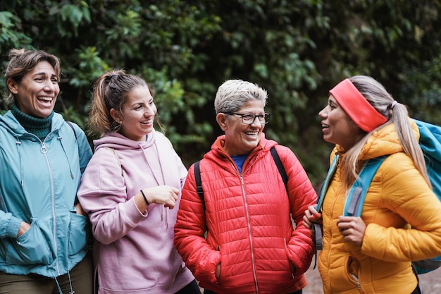 Gemischtrassige Frauen, die sich während des Trekkingtages im Bergwald gemeinsam amüsieren