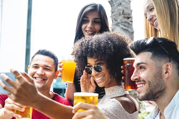 Gemischtrassige Freunde, die Gruppen-Selfie machen, lächeln in die Kamera, lachende junge Leute, die draußen stehen und Spaß haben, fröhliche Leute in der Kneipe, die ein lustiges Konzept haben